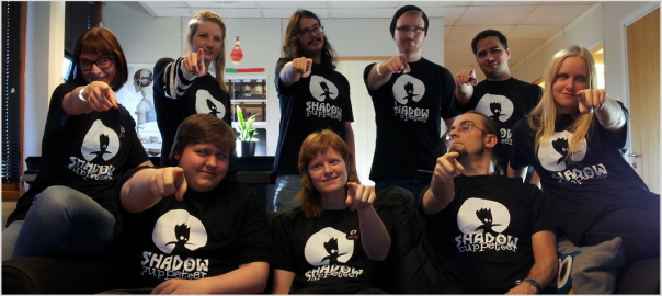 Shadow Puppeteer team in swag t-shirts pointing